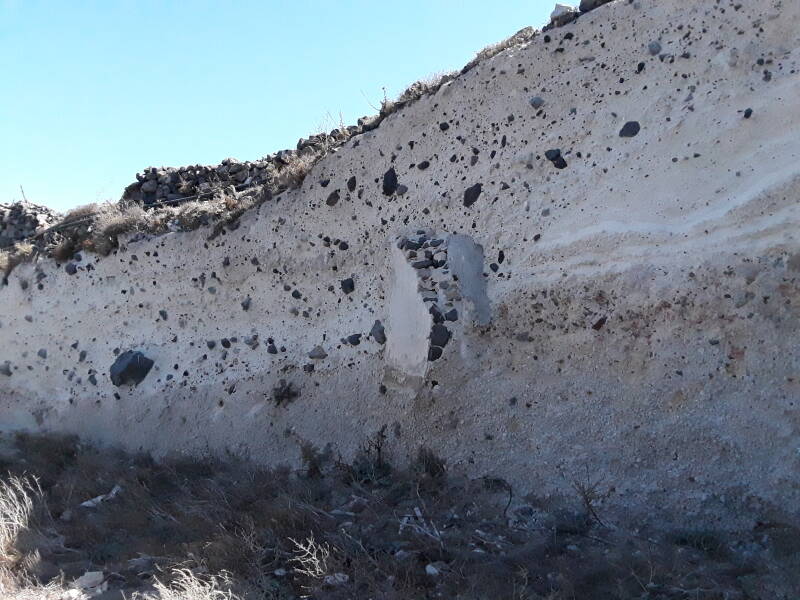 White tephra, largely white tufa with black stones embedded in it.