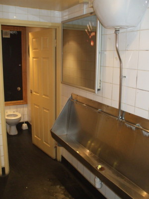 Large stainless steel urinal in a London pub.