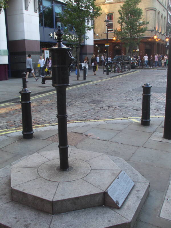 The famous water pump found to be the focus of the 1854 cholera epidemic in London.  Narrow street, John Snow pub in the background.