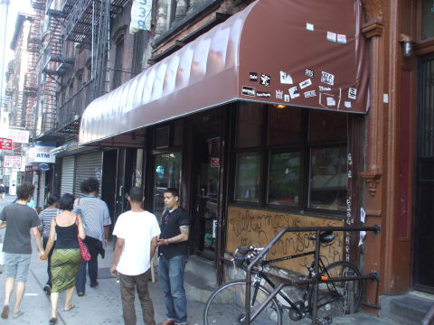 Exterior of Welcome To The Johnson's Bar on Rivington Street on the Lower East Side in New York: brown awning, windows and doors.
