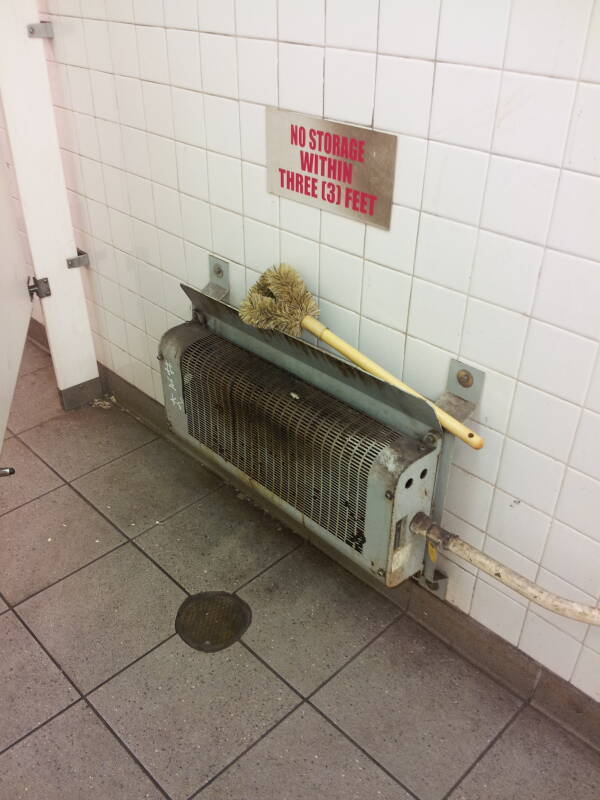Radiator and large scrub brush in the Delancey Street — Essex Street station of the New York City MTA subway system in Manhattan.