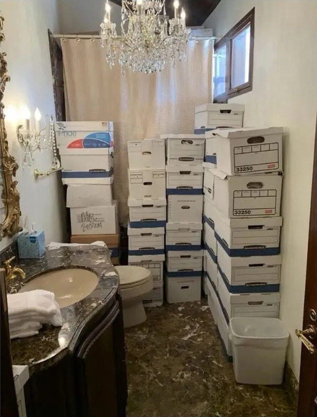Highly sensitive U.S. Government documents piled in a tacky bathroom with a chandelier over the toilet.